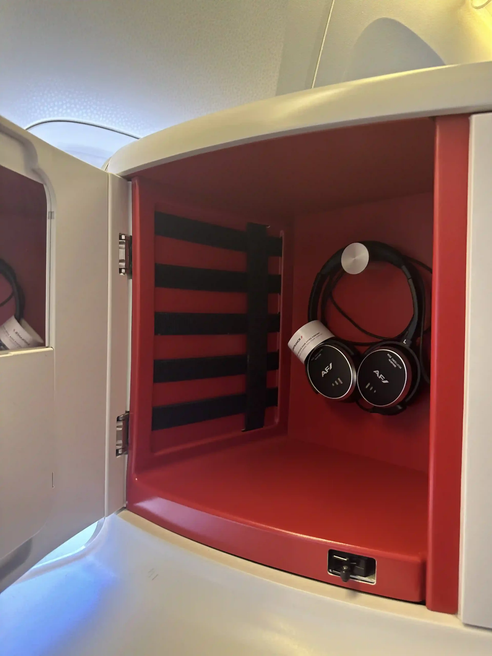 a small white and red box with black headphones inside