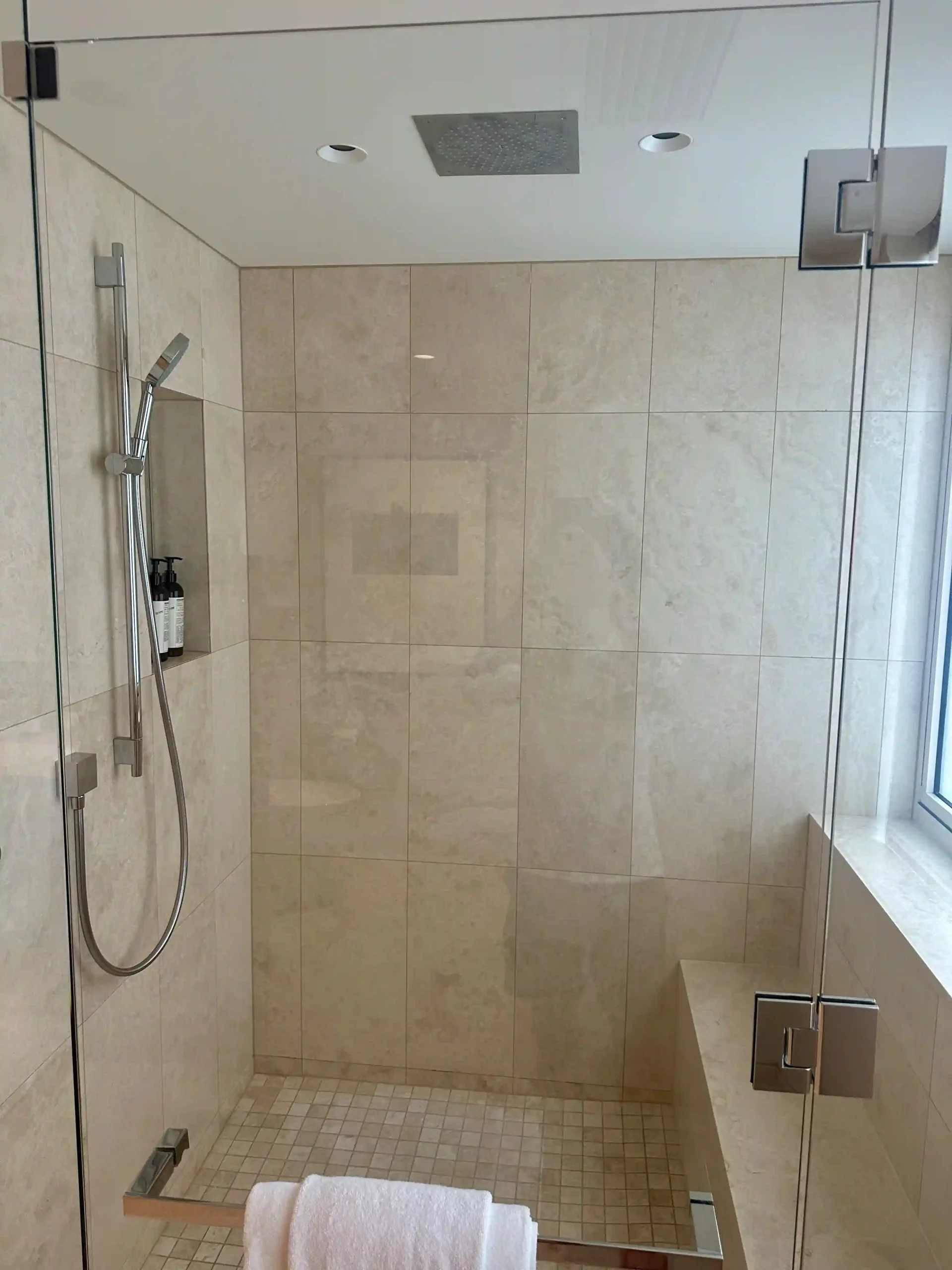 a shower with a bench and a shower head