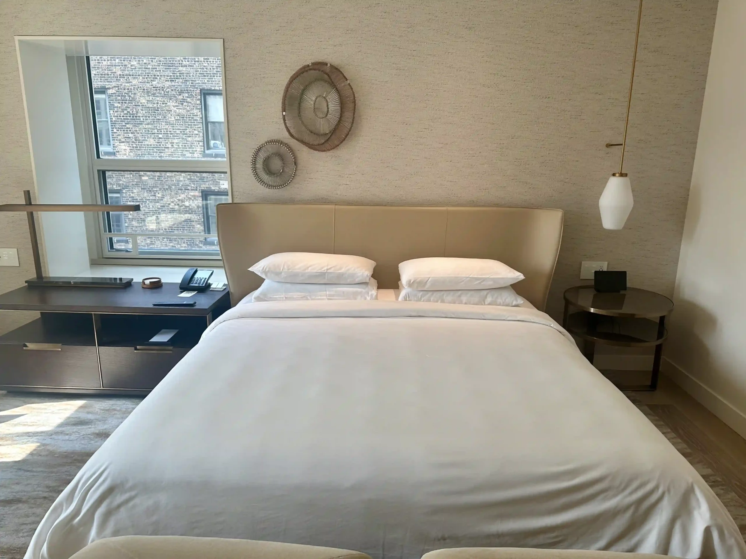 a bed with white sheets and pillows in a room