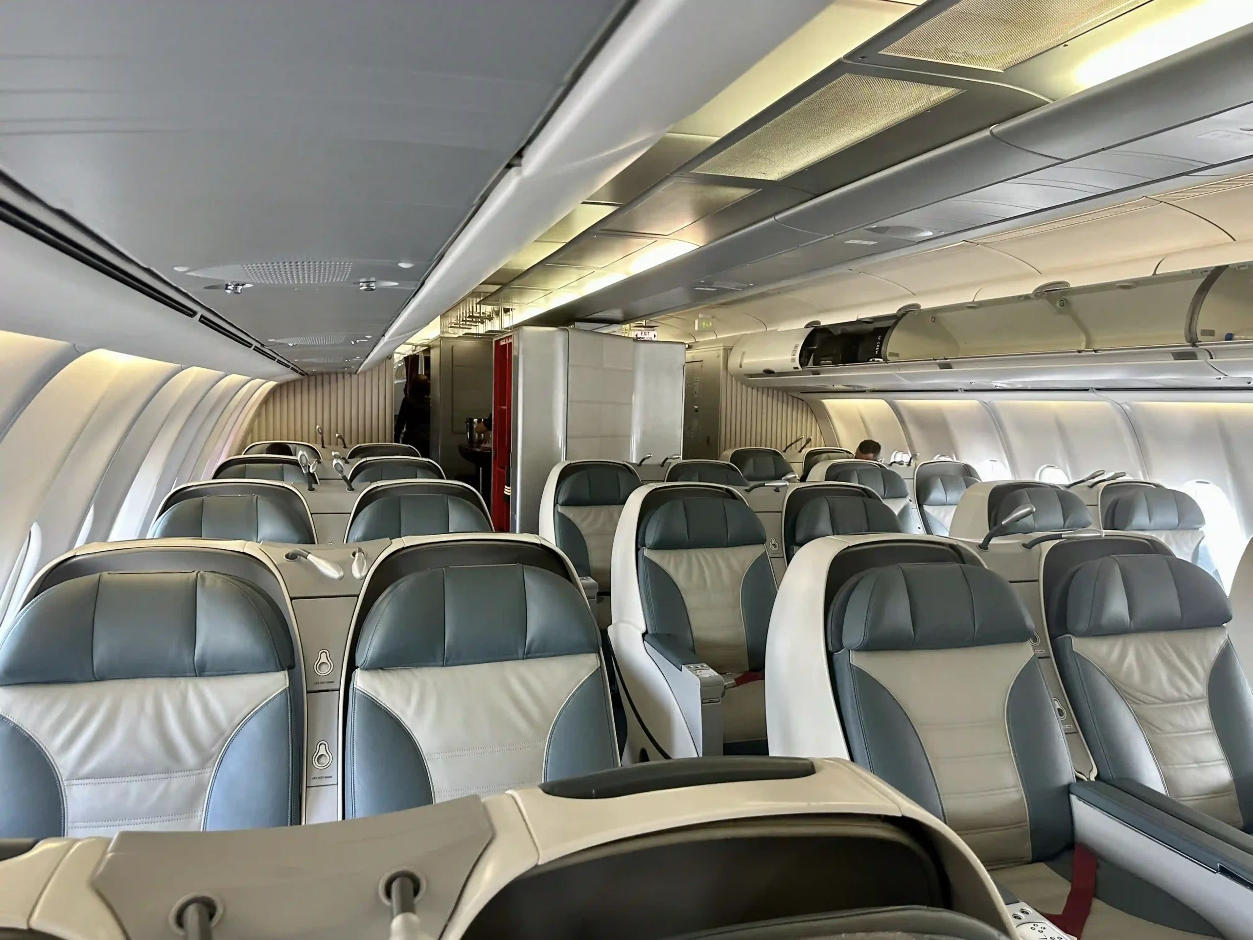 a plane with seats and people standing in the background
