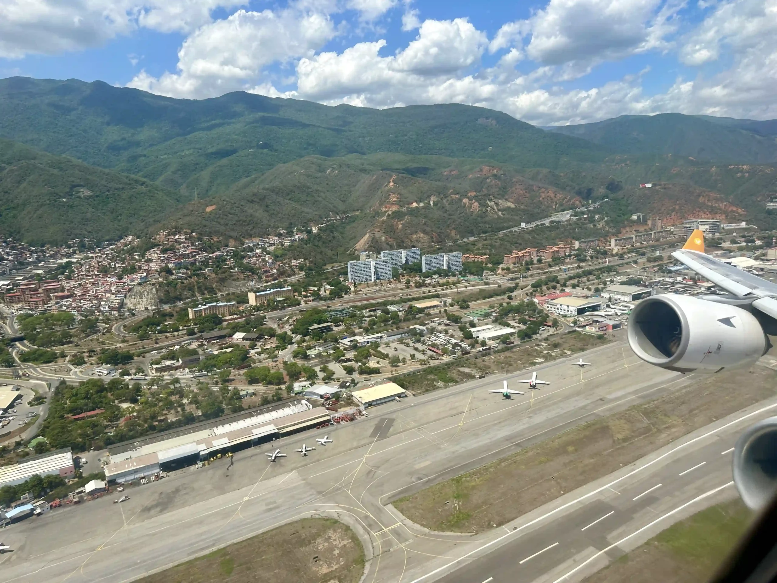 an airplane on a runway with a city and buildings in the background