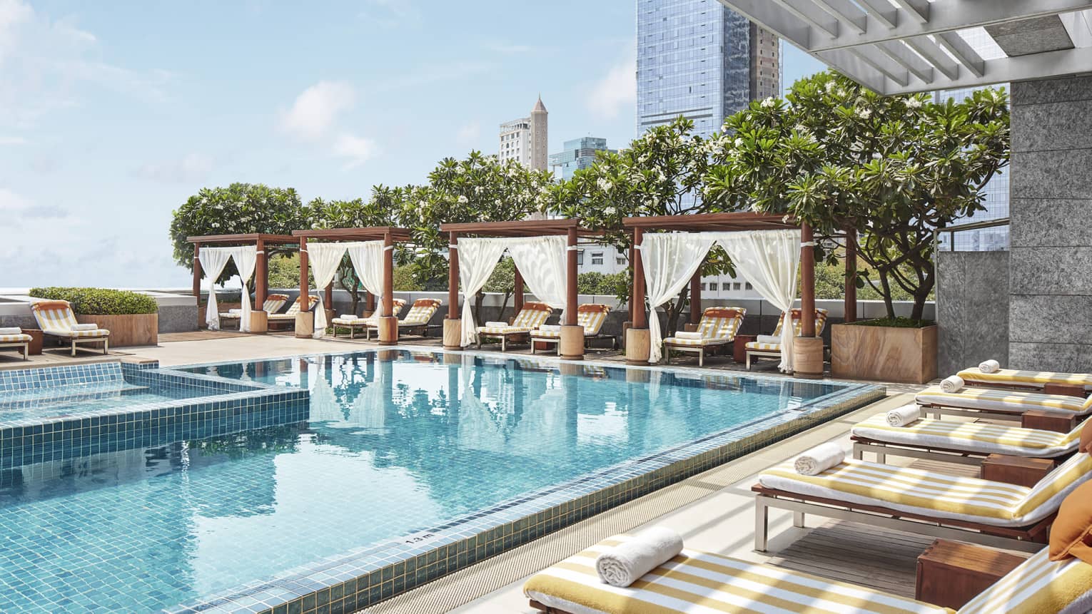 a pool with lounge chairs and trees