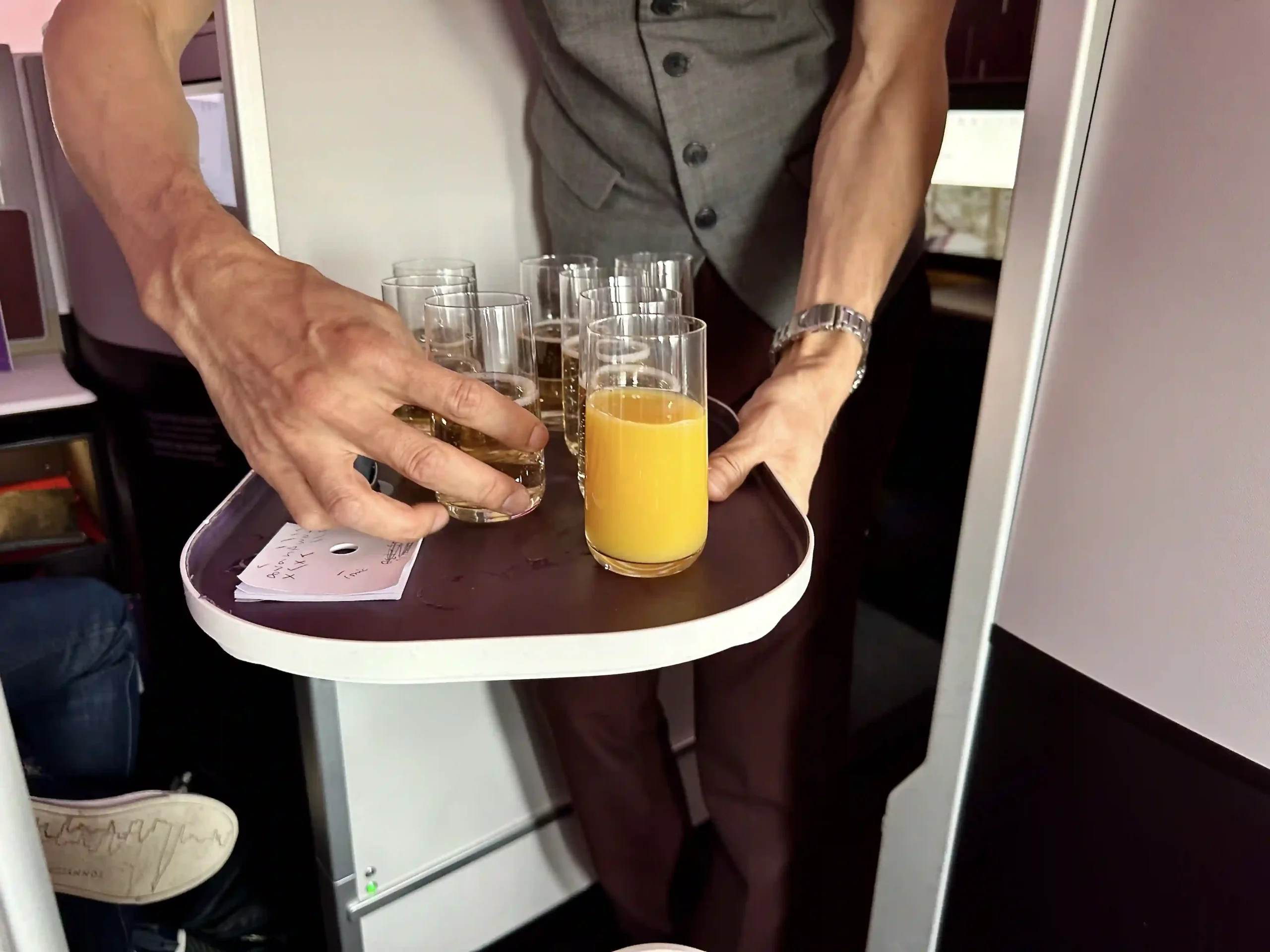 a man holding a tray with glasses of liquid