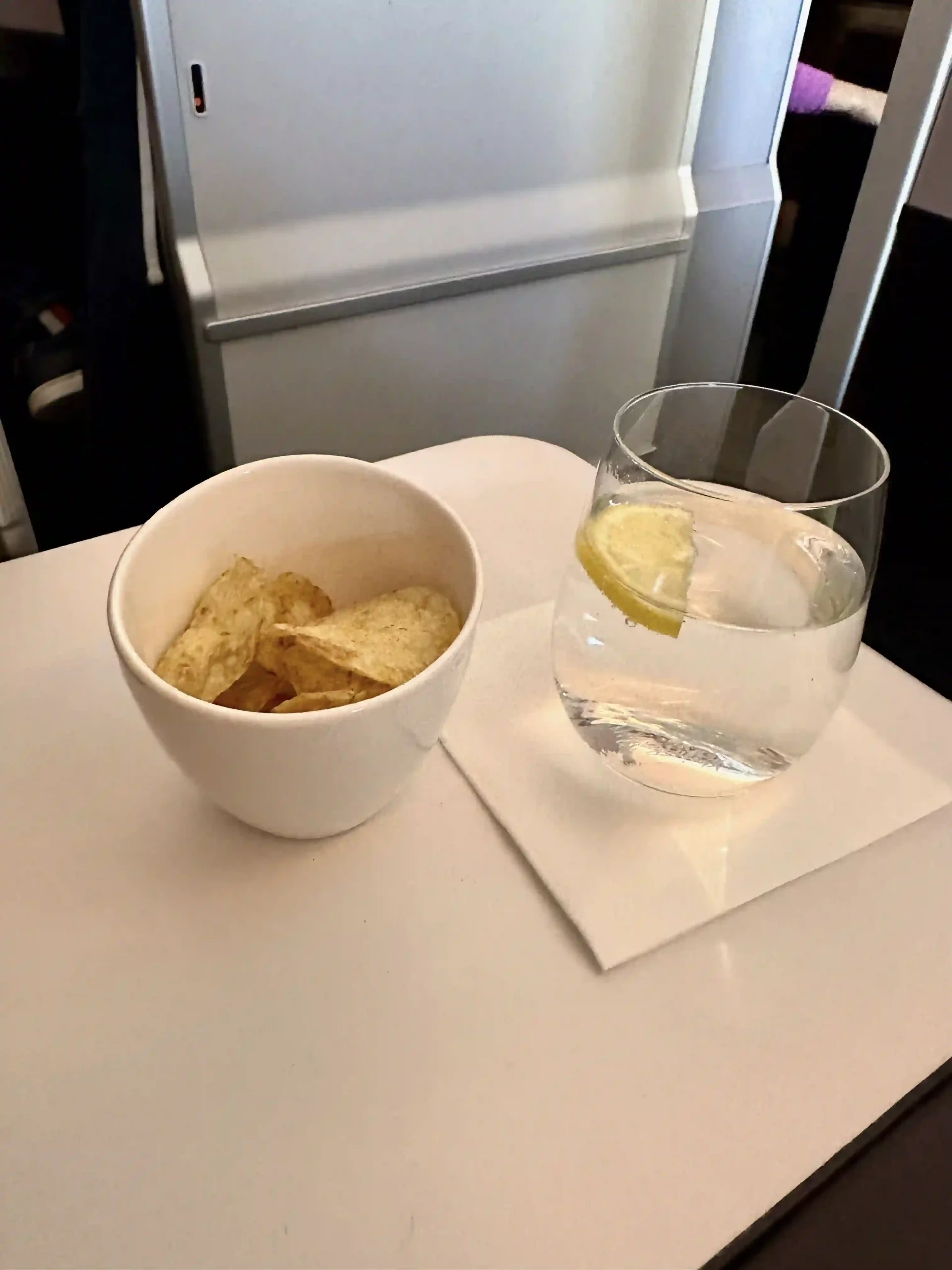 a bowl of chips and a glass of water on a table