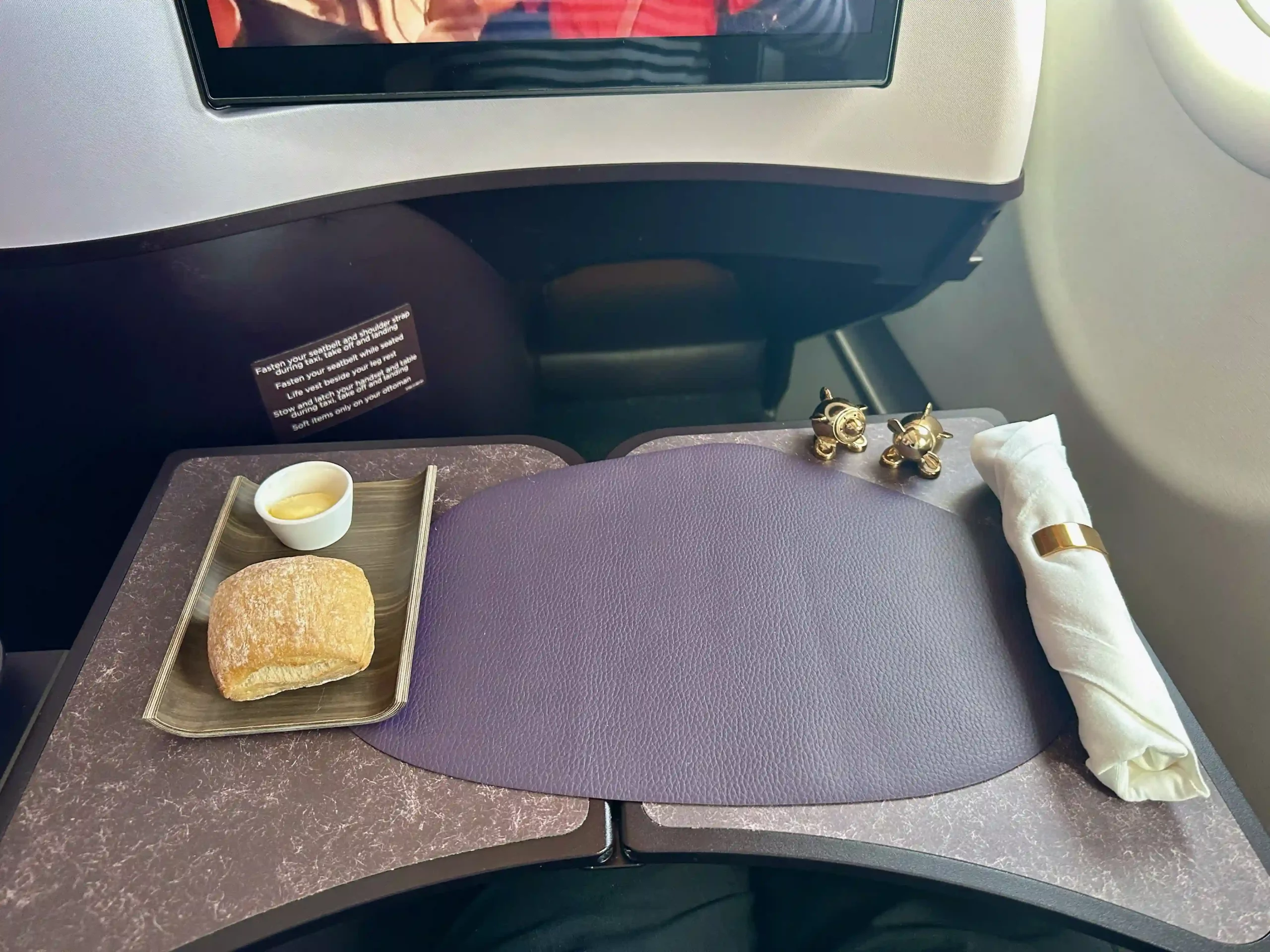 a tray with food on it and a tv on the side of the seat