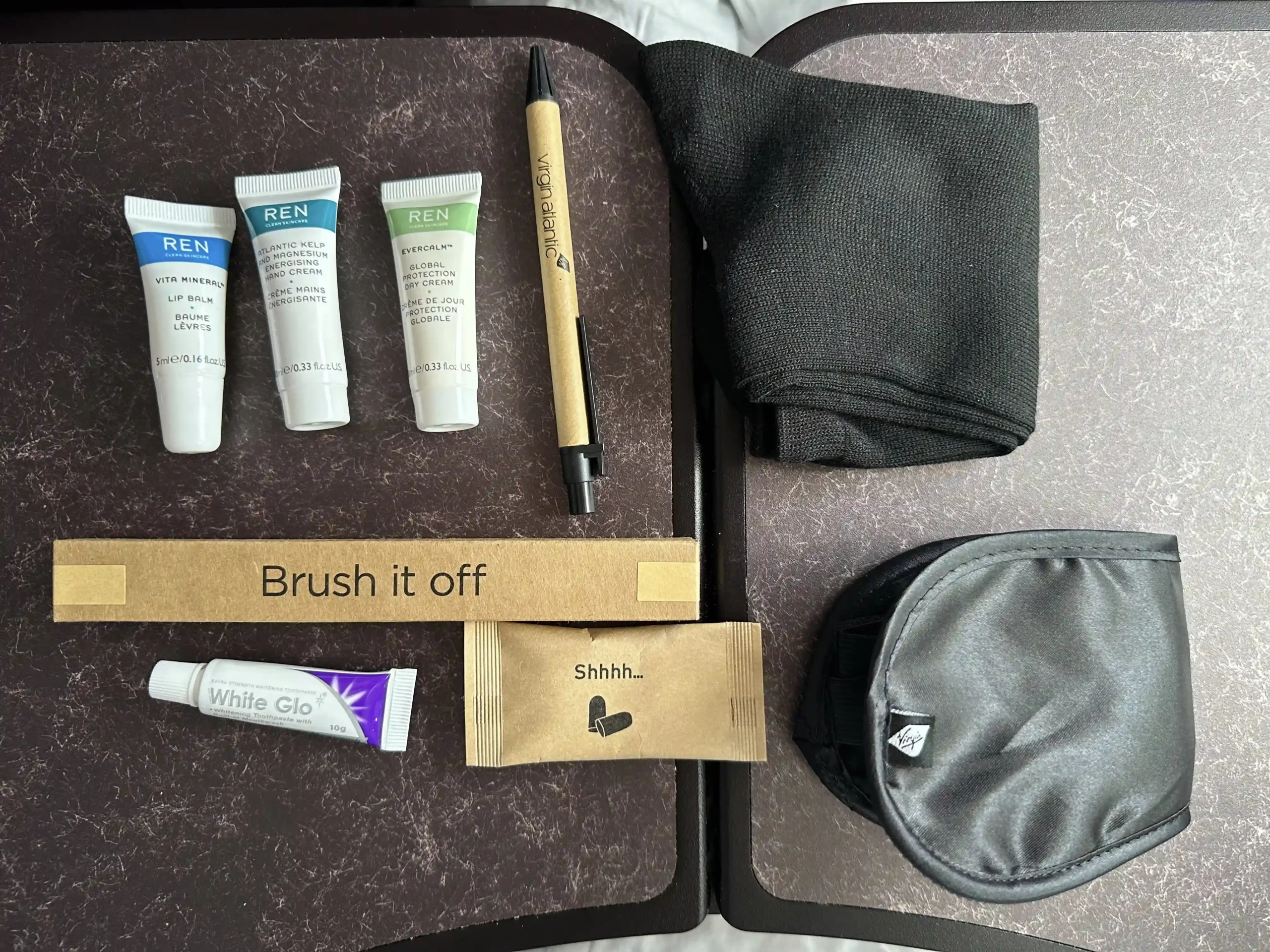 a group of small tubes of paint and a black bag on a table