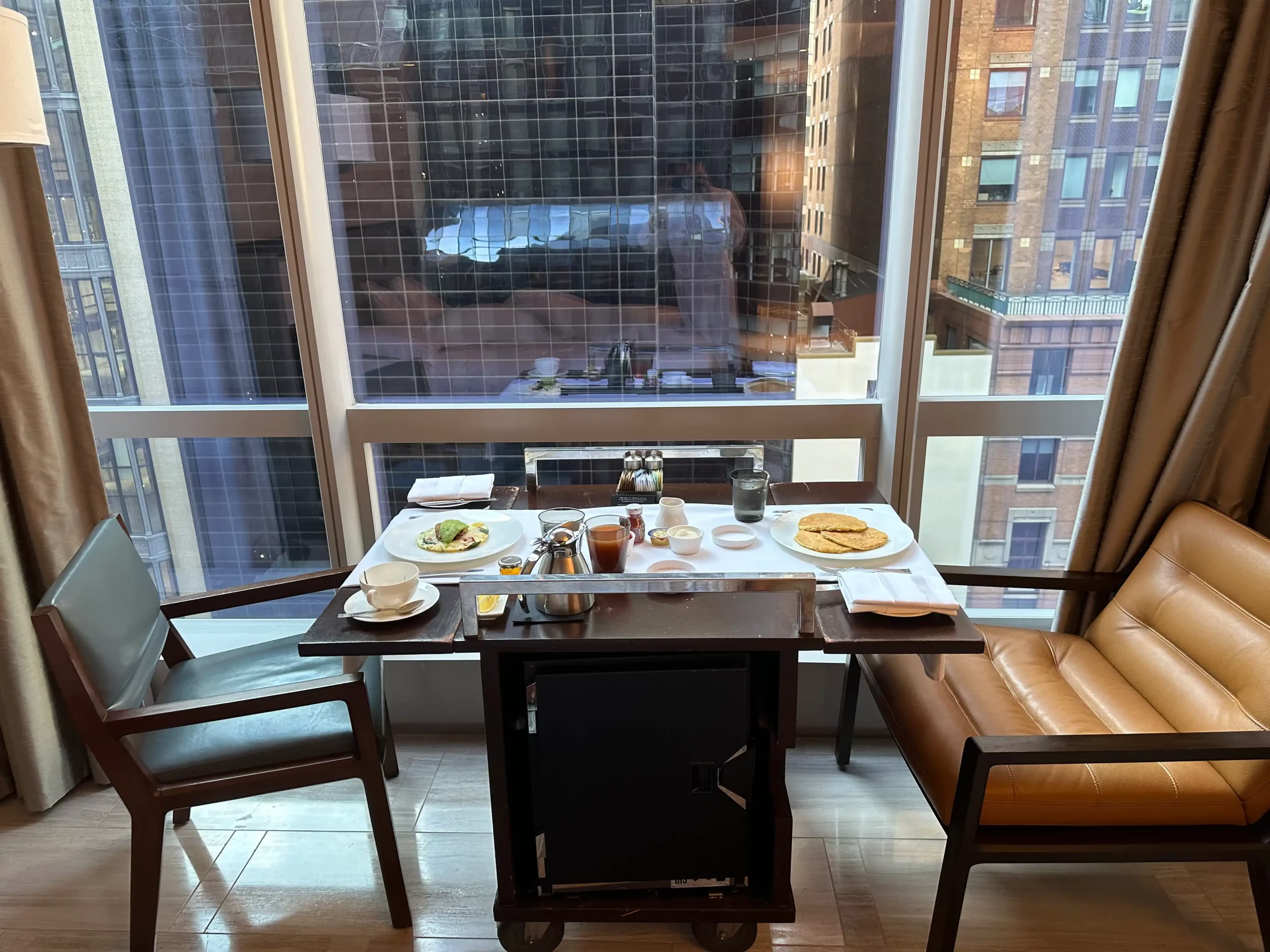 a table with food on it and chairs in front of a window
