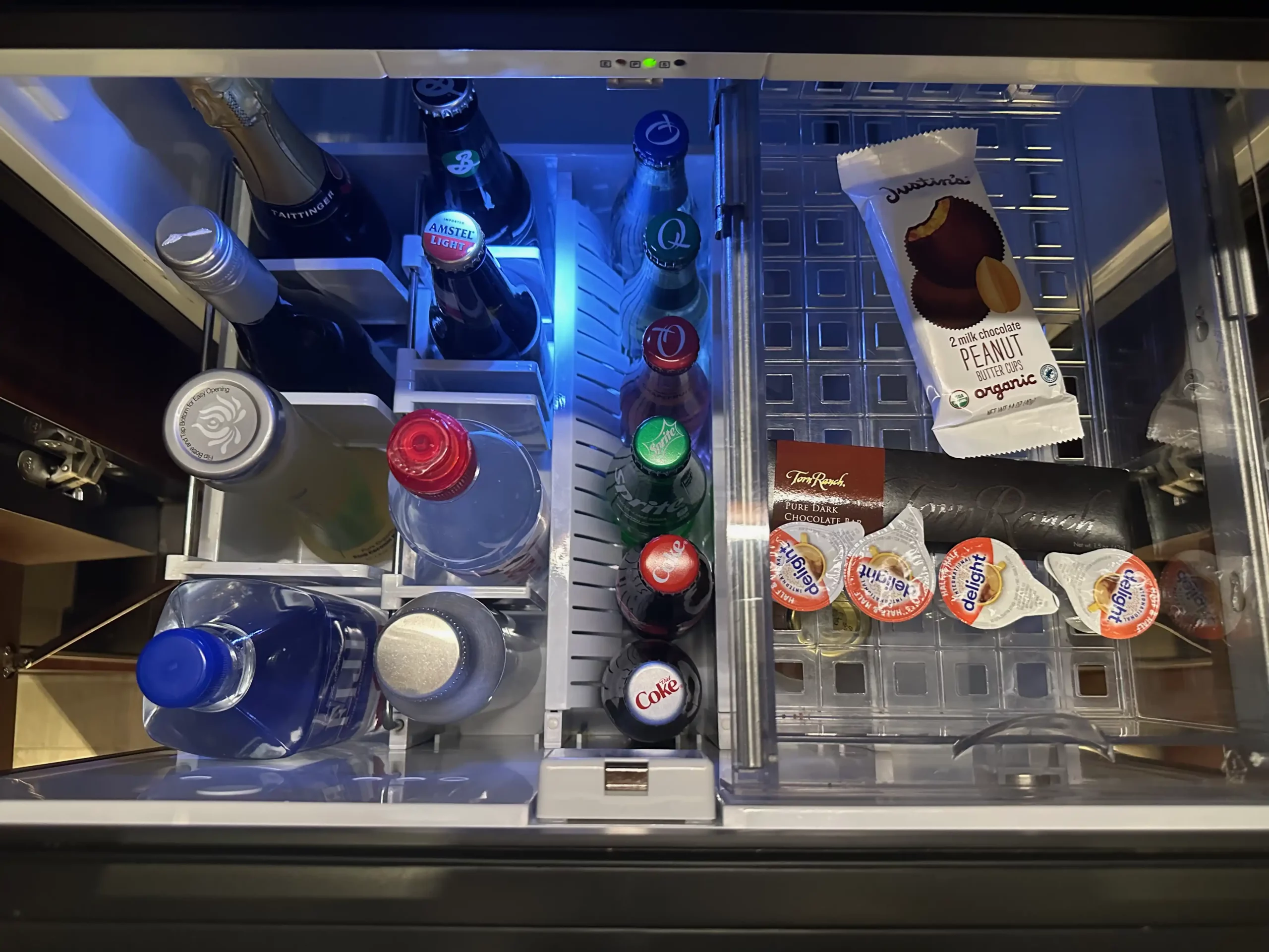 a refrigerator with bottles and snacks