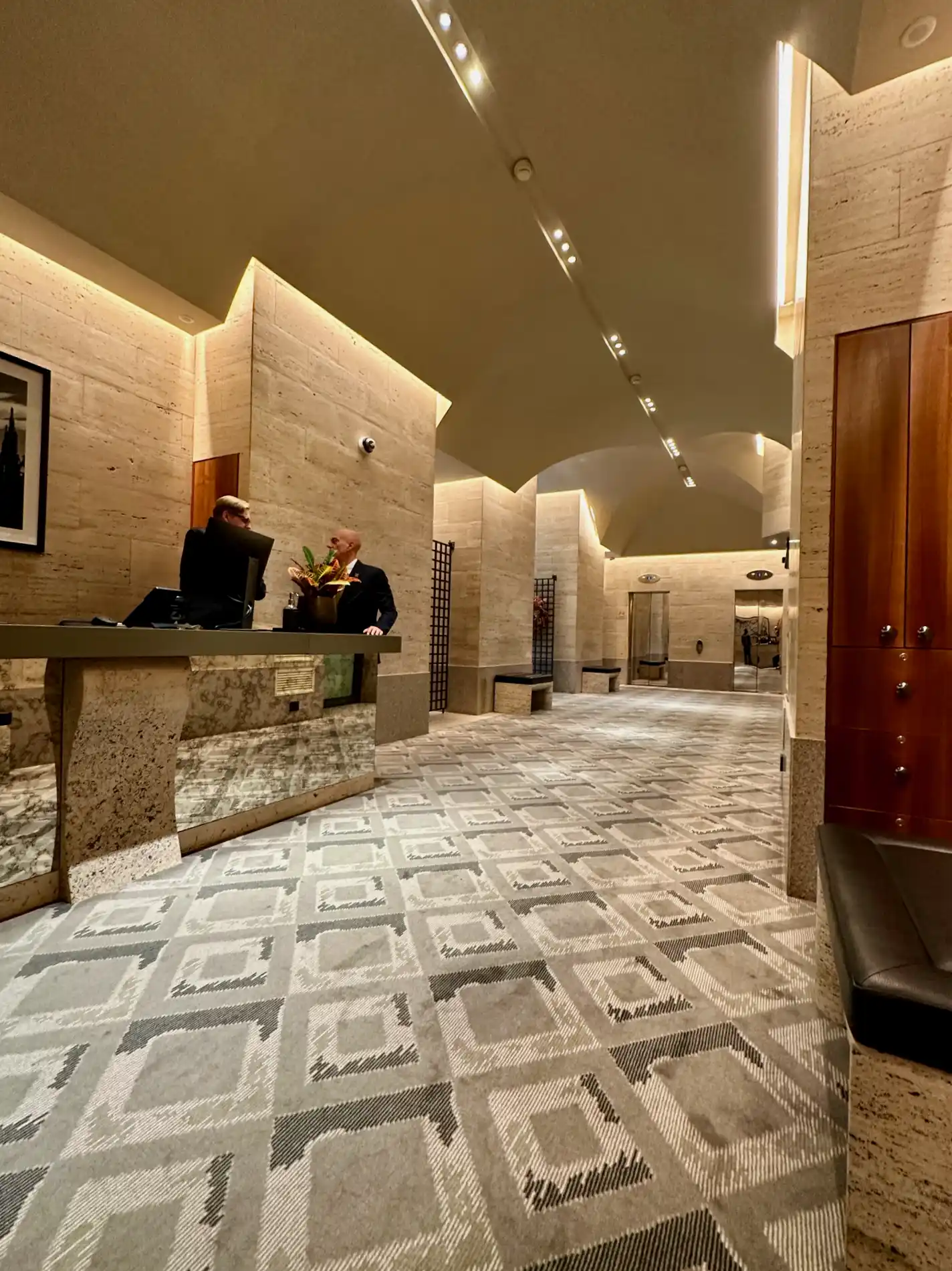 a man standing at a counter in a hotel lobby