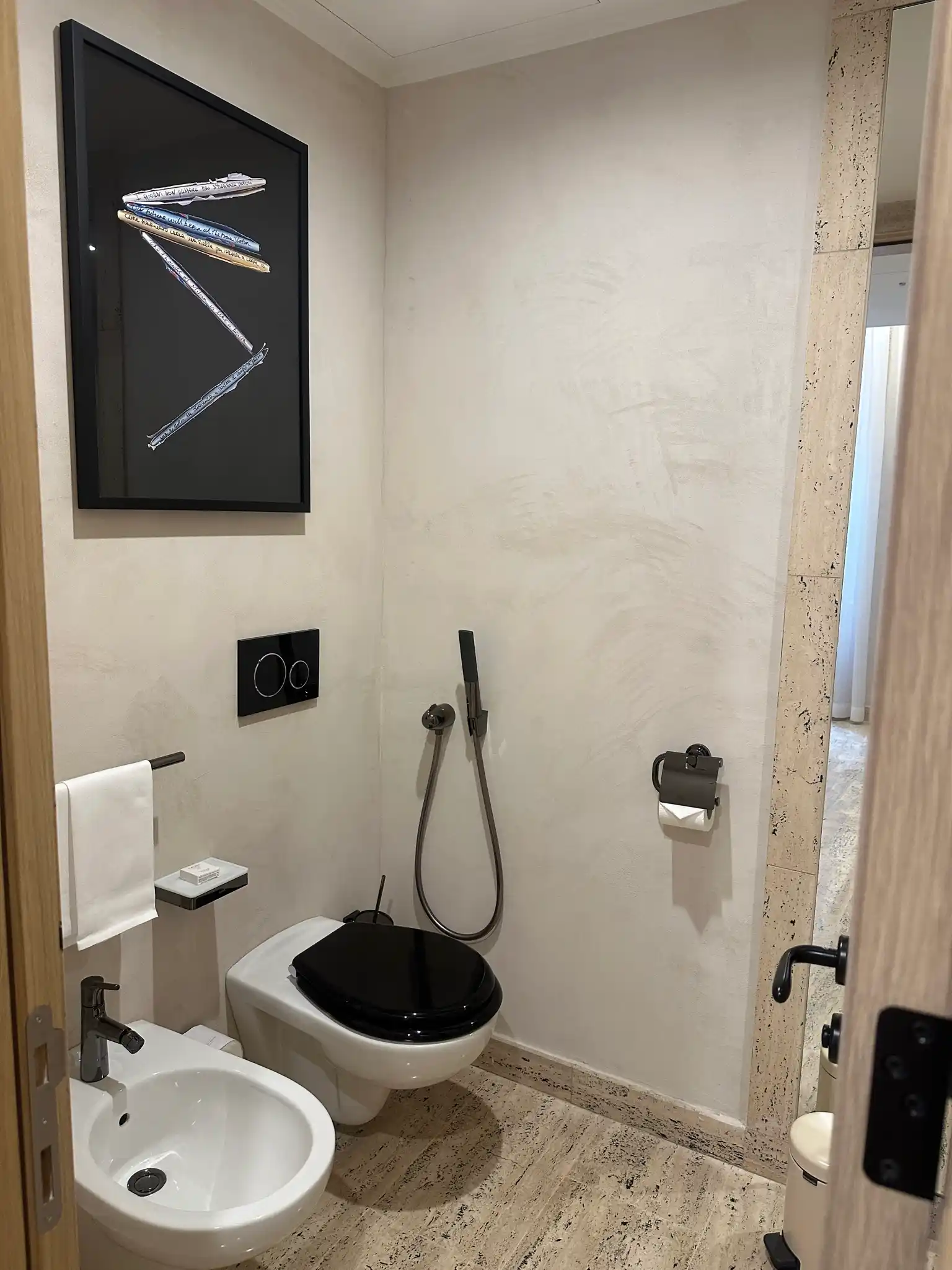 a bathroom with a toilet and a picture on the wall