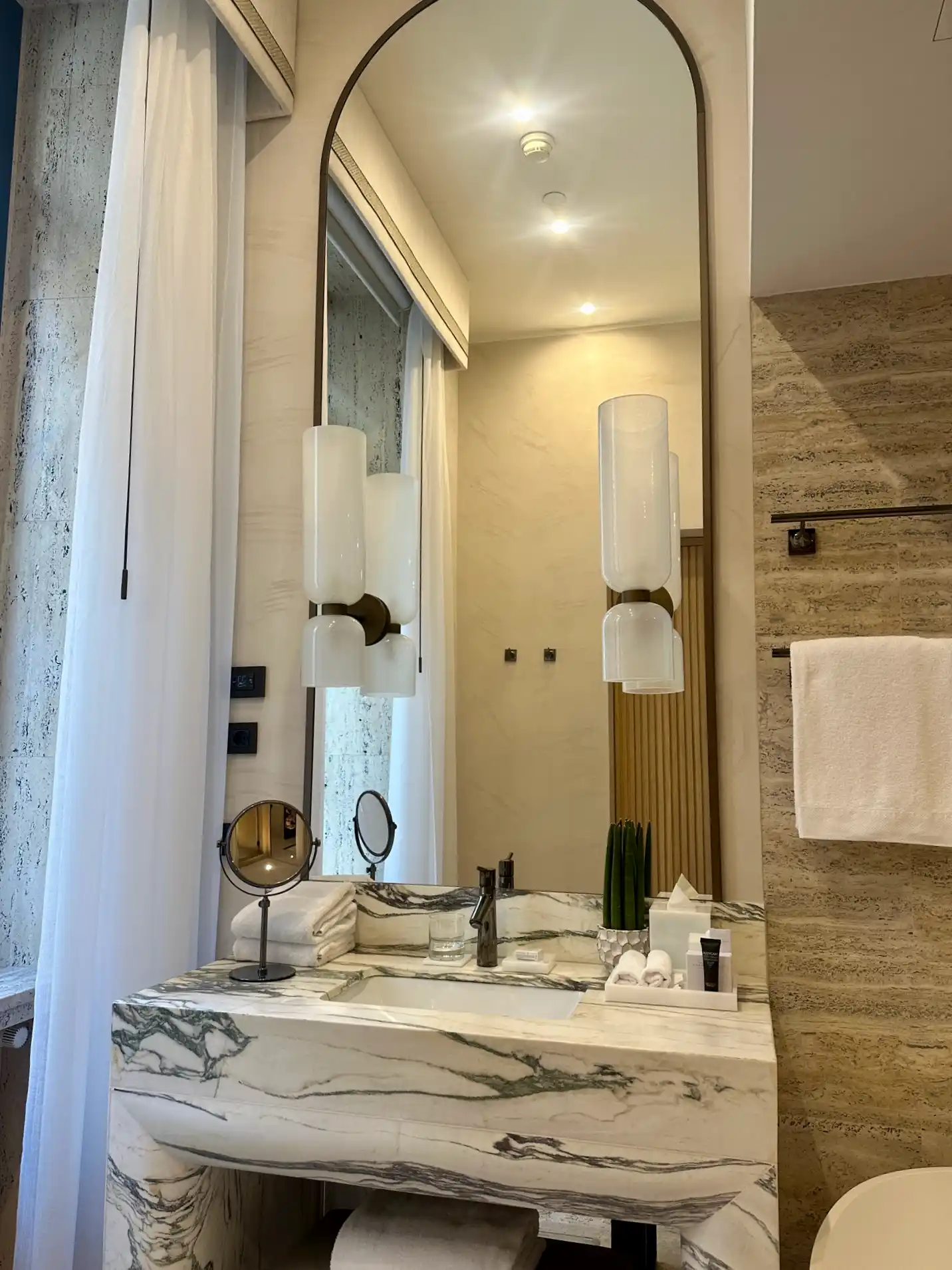 a bathroom with a marble sink and mirror
