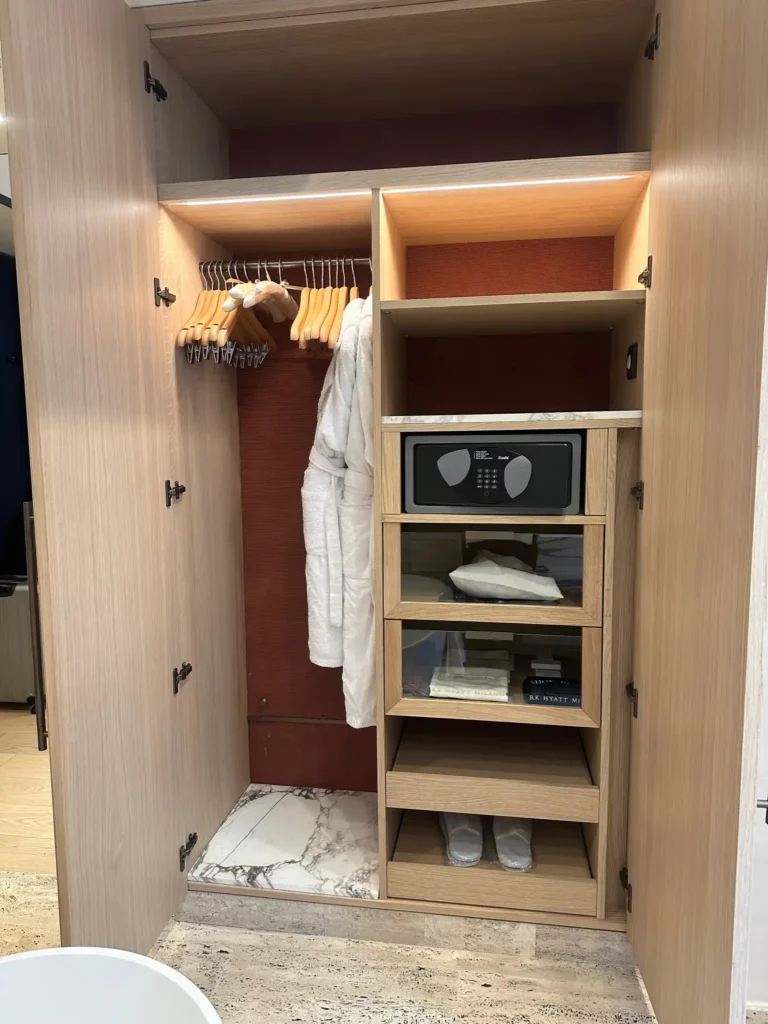 a closet with a white robe and a microwave