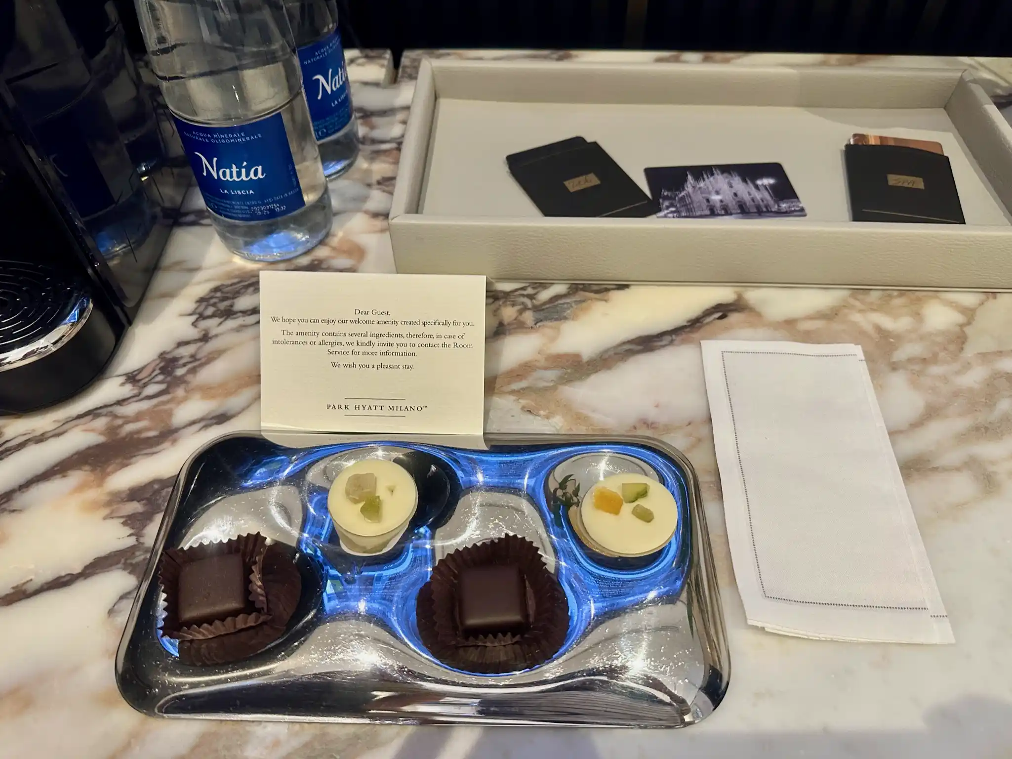 a tray of chocolates and a note on a marble table