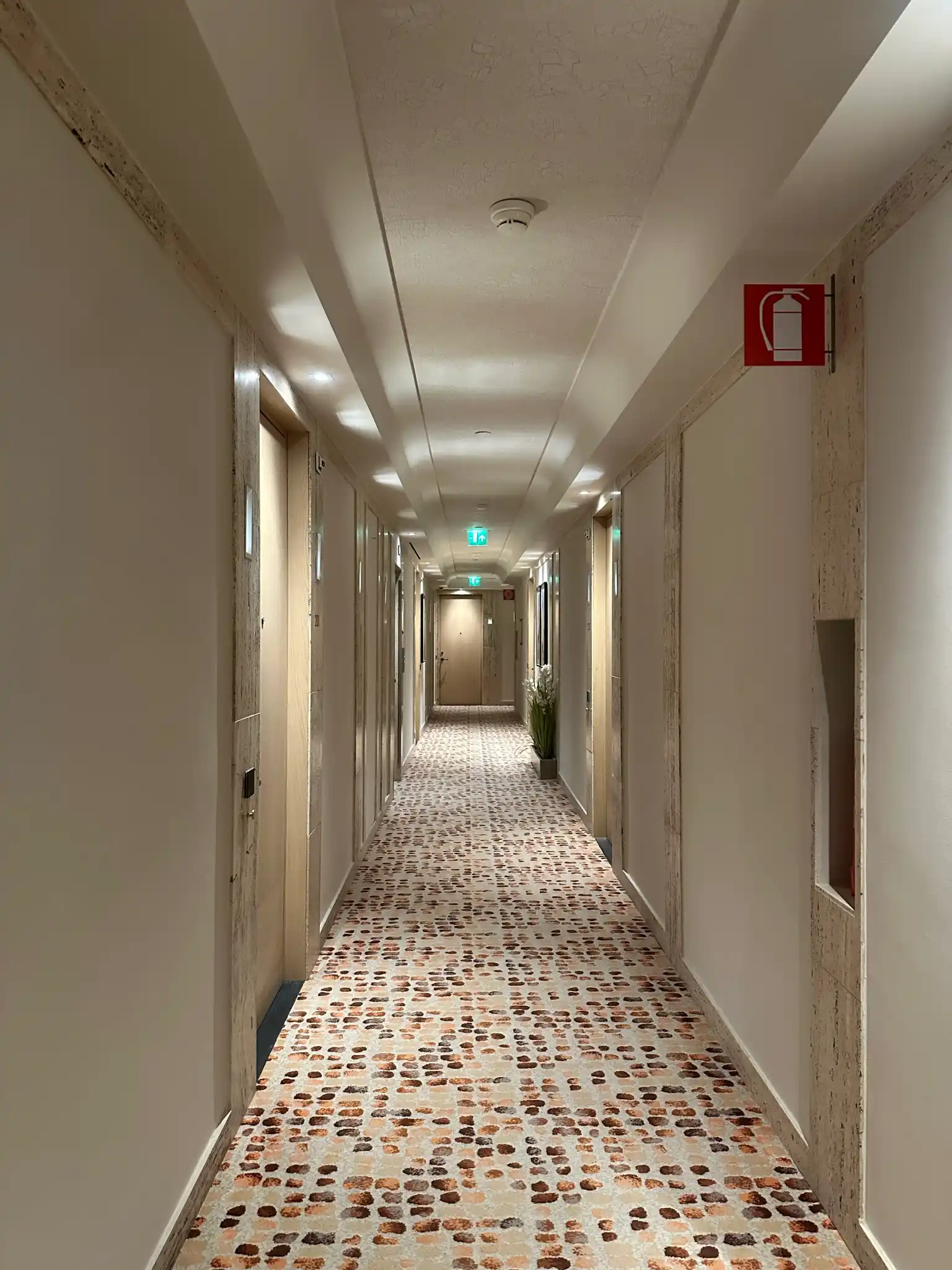 a long hallway with a fire extinguisher sign