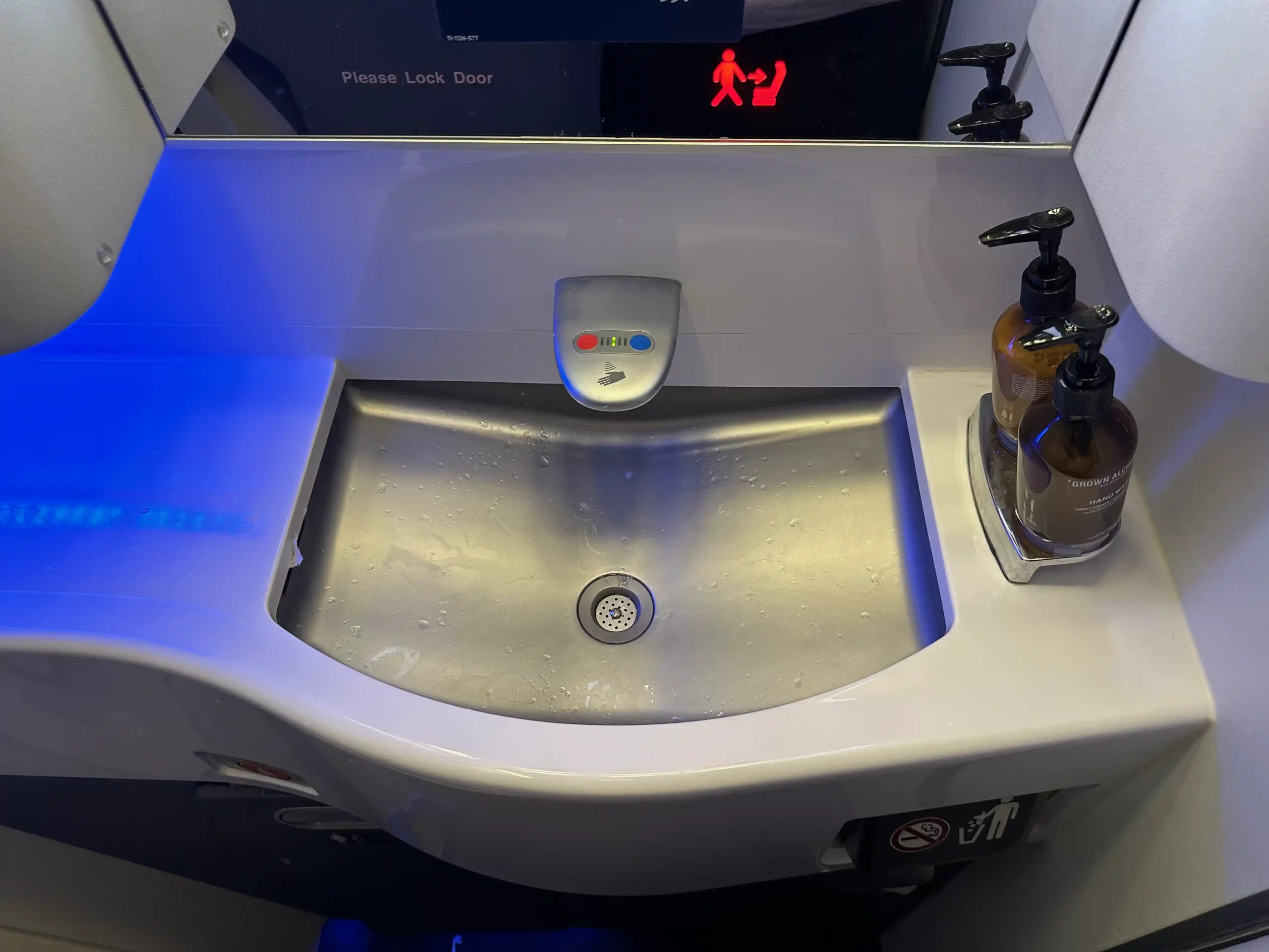 a sink with soap dispenser and a bottle of liquid