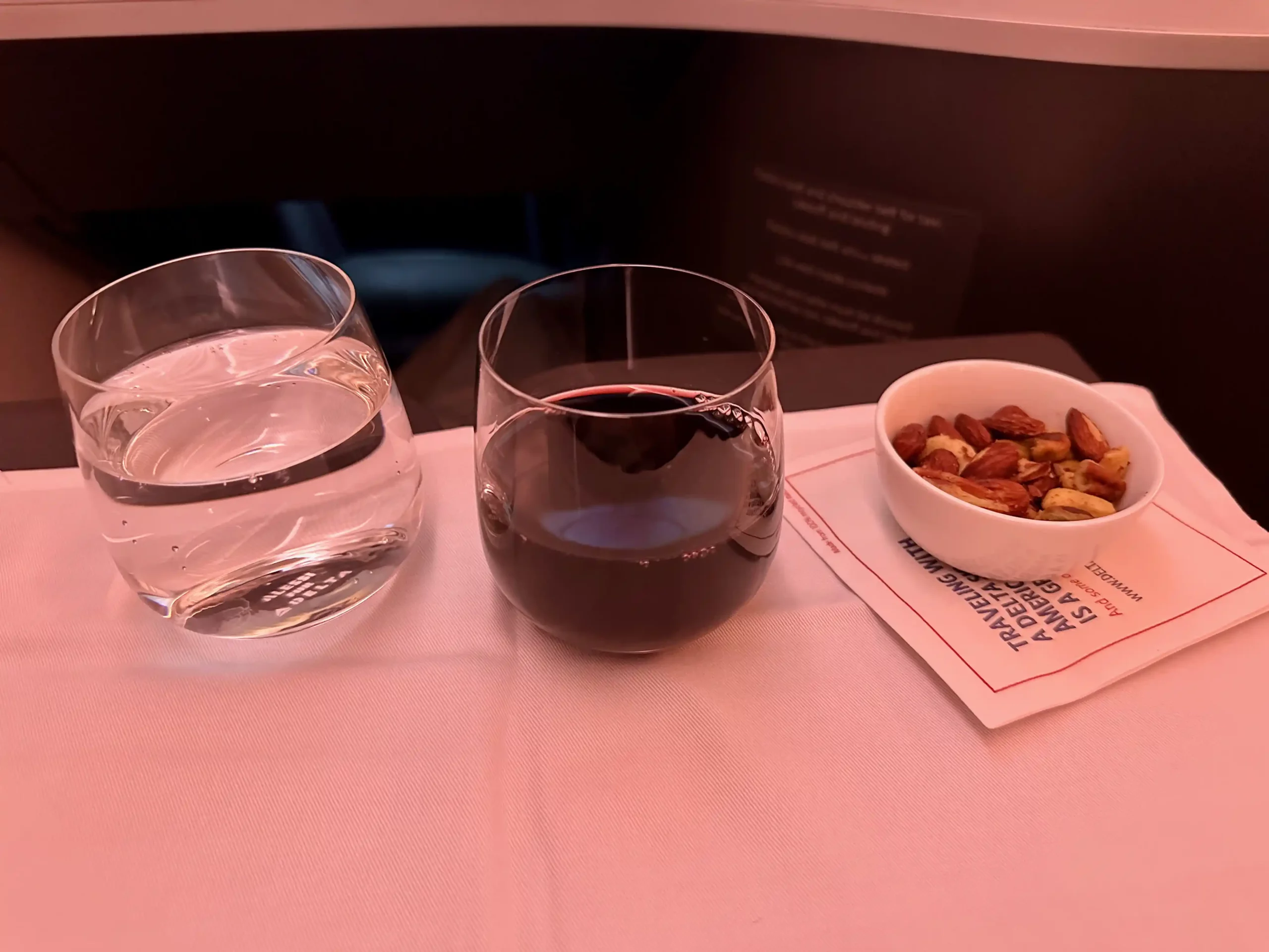 a glass of wine and a bowl of nuts