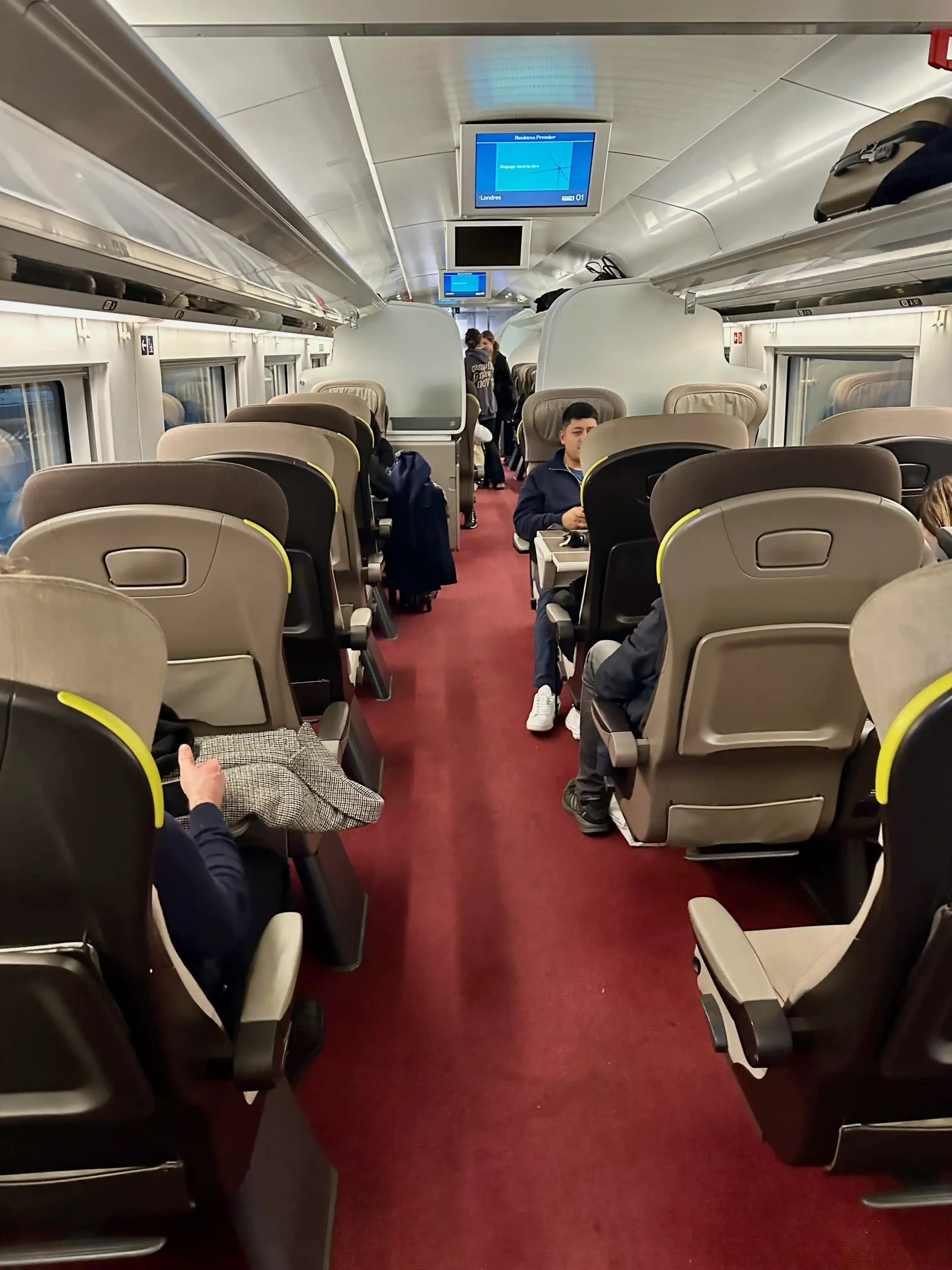 a group of people sitting on chairs in a train