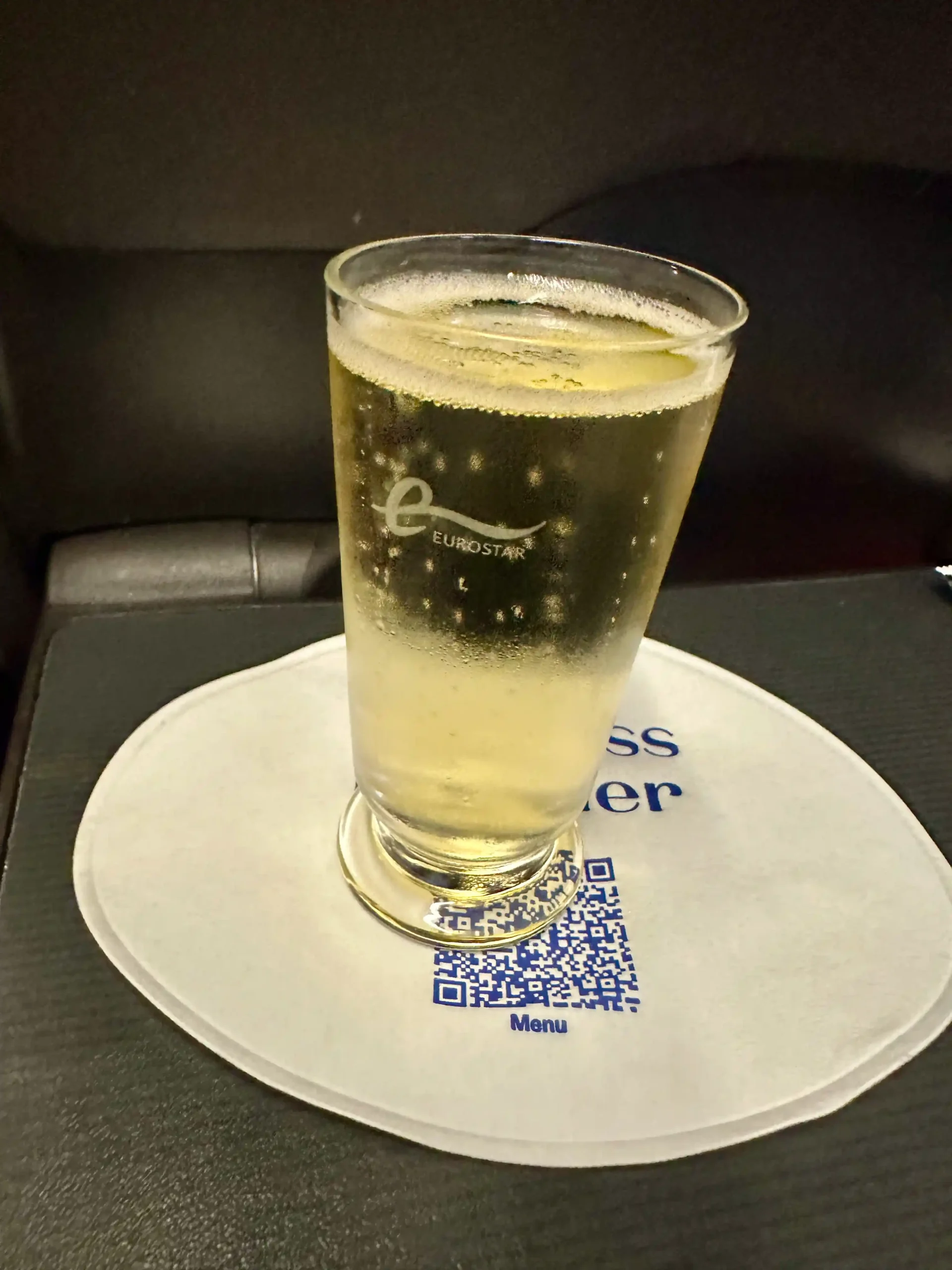 a glass of sparkling wine on a white plate
