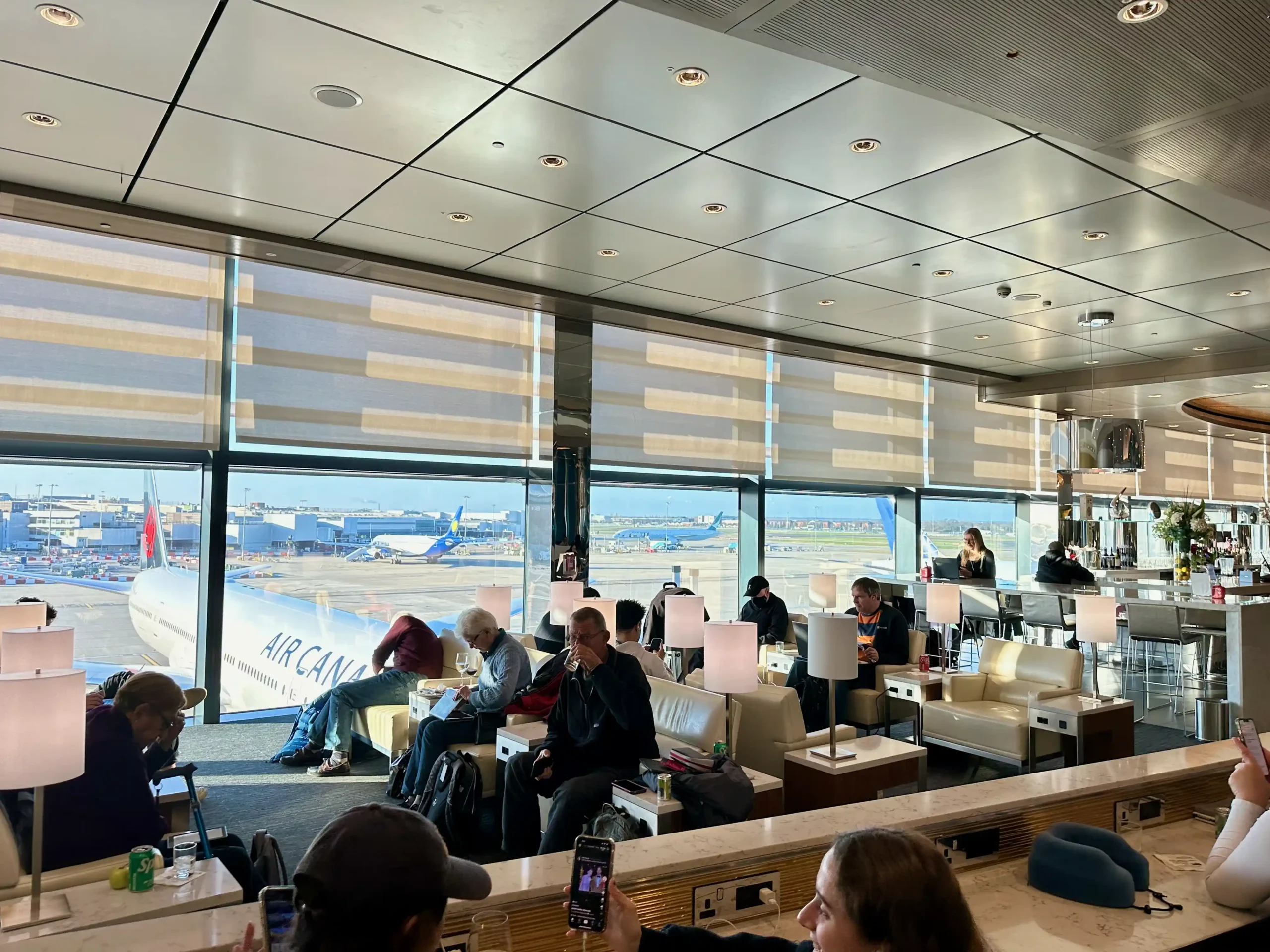 people sitting at tables in a room with a large window