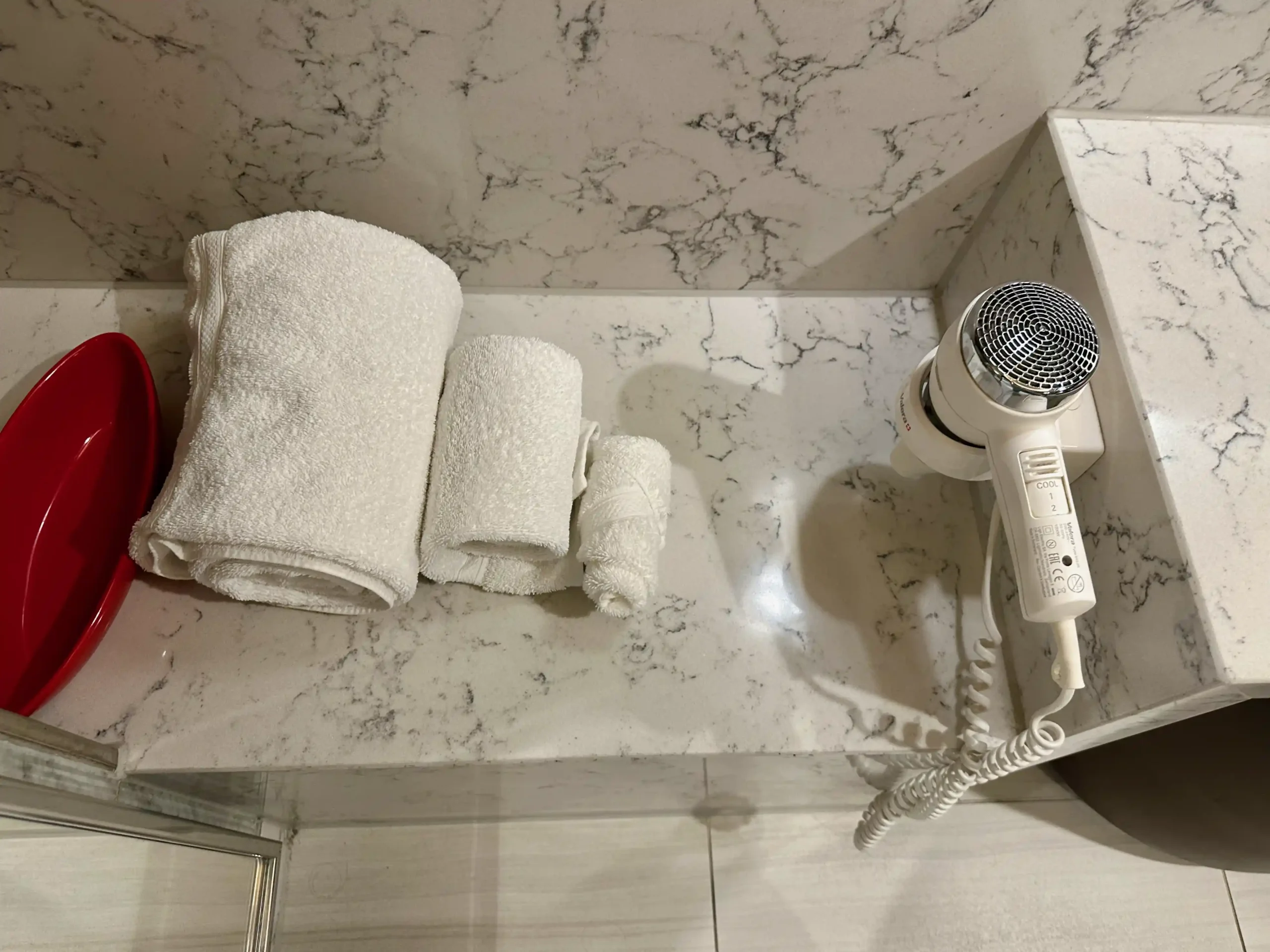 a white towel and hair dryer on a marble counter