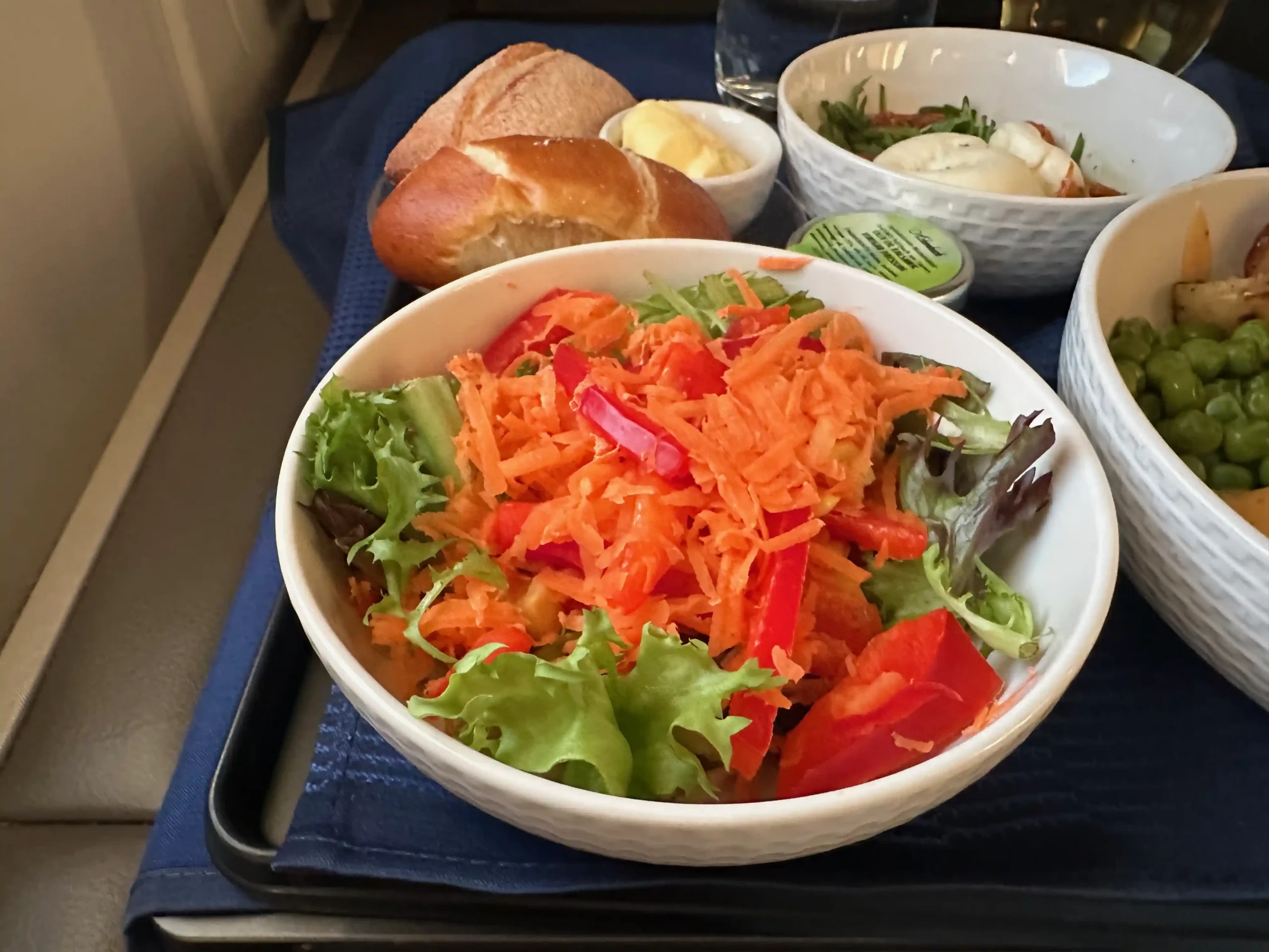 a bowl of salad and bread on a tray