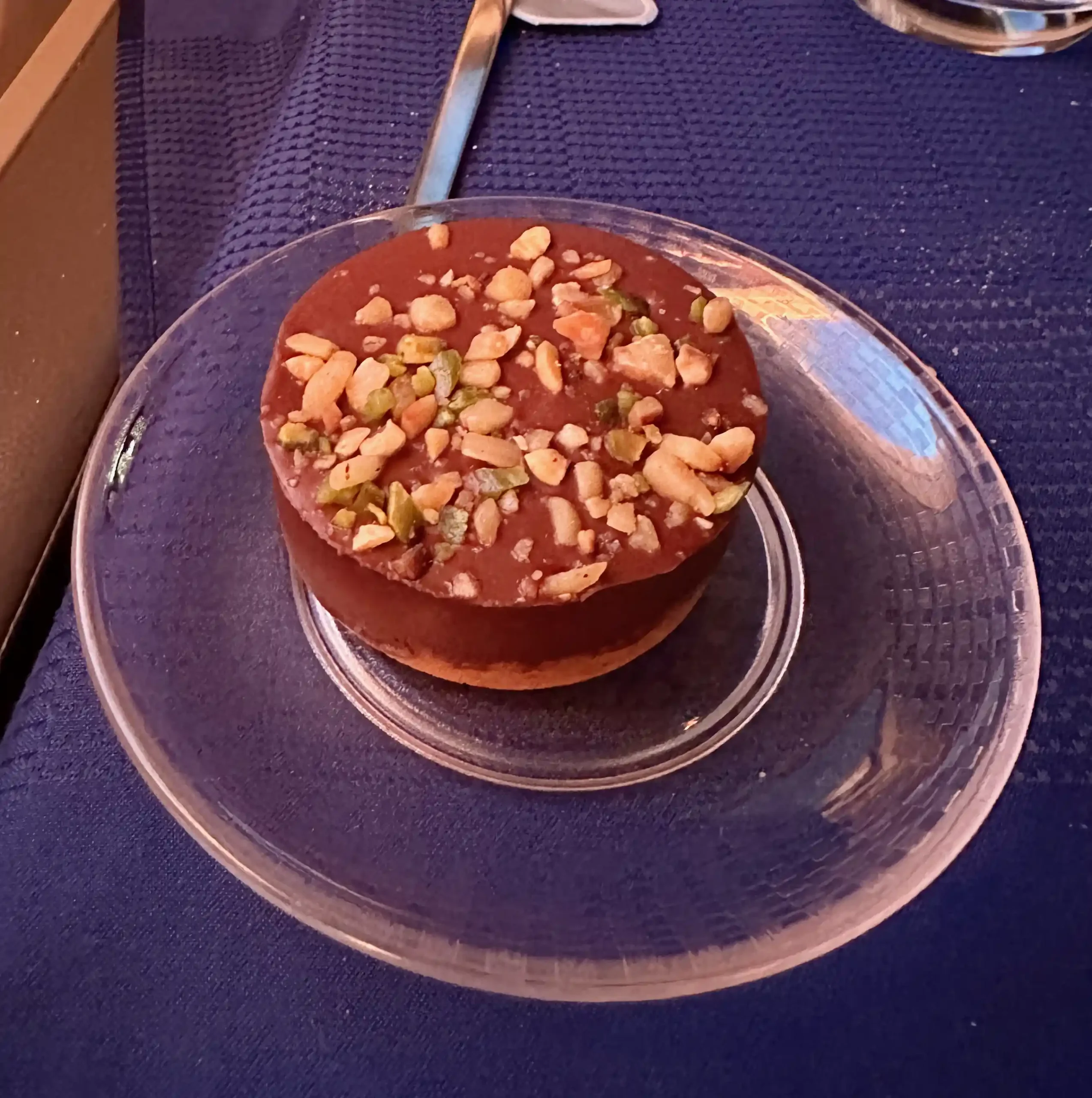 a chocolate cake with nuts on a clear plate