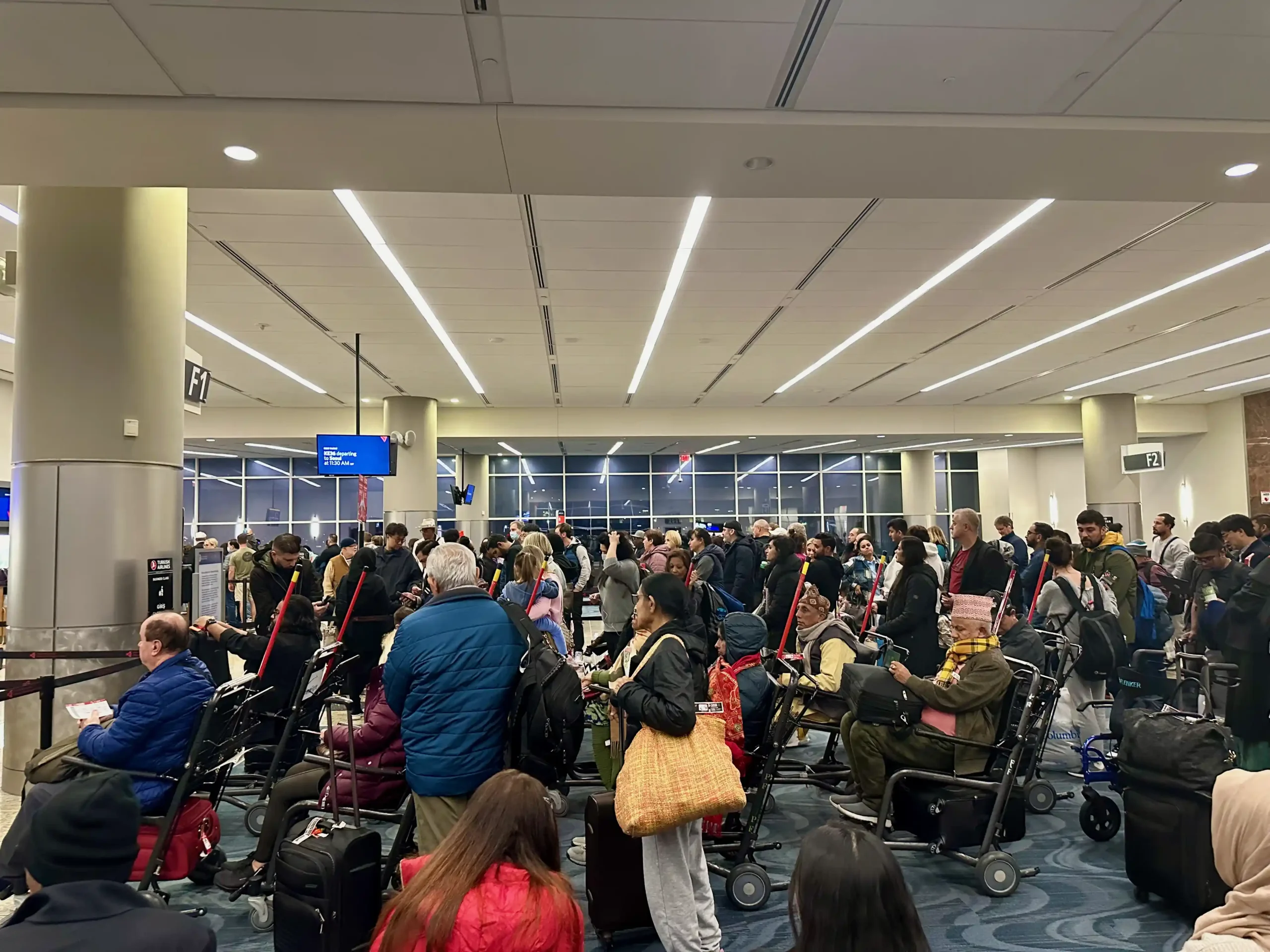 a group of people in a room with luggage